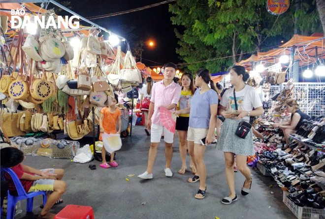 It is high time for the city to develop many diversified and healthy services to serve tourists at night. Tourists are pictured shoping at the Son Tra night market.