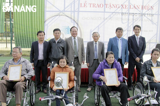 Trường Đại học Duy Tân phối hợp với Báo Đà Nẵng trao tặng xe lăn điện cho người khuyết tật tháng 1-2019. Ảnh: H.T