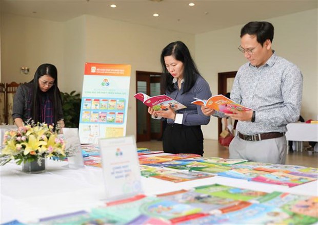 Đại biểu dự hội thảo xem các bản mẫu sách giáo khoa do Nhà xuất bản Giáo dục Việt Nam biên soạn. (Ảnh: Thanh Tùng /TTXVN)