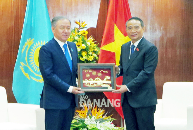 Bí thư Thành ủy Trương Quang Nghĩa (phải) tặng quà lưu niệm ông Nurlan Nigmatulin, Chủ tịch Thượng viện Kazakhstan.    Ảnh: S.TRUNG