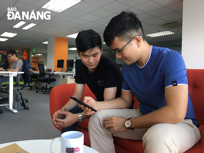 Hai kỹ sư Võ Tất Thành (bên phải) và Trần Ngọc Quốc trao đổi về ứng dụng “Cho và Nhận”.  Ảnh: P.L