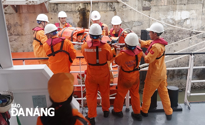 Lực lượng cứu nạn đưa ngư dân S lên cầu cảng để bàn giao cho cơ quan chức năng đưa bào bệnh viện cấp cứu.