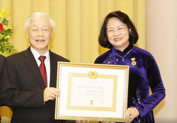 Tổng Bí thư, Chủ tịch nước Nguyễn Phú Trọng trao Huy hiệu 40 năm tuổi Đảng tặng đồng chí Đặng Thị Ngọc Thịnh. Ảnh: TTXVN