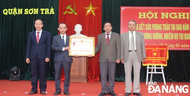 Đại diện Ban Tổ chức Quận ủy Sơn Trà (bên trái) đón nhận Huân chương Lao động hạng ba.