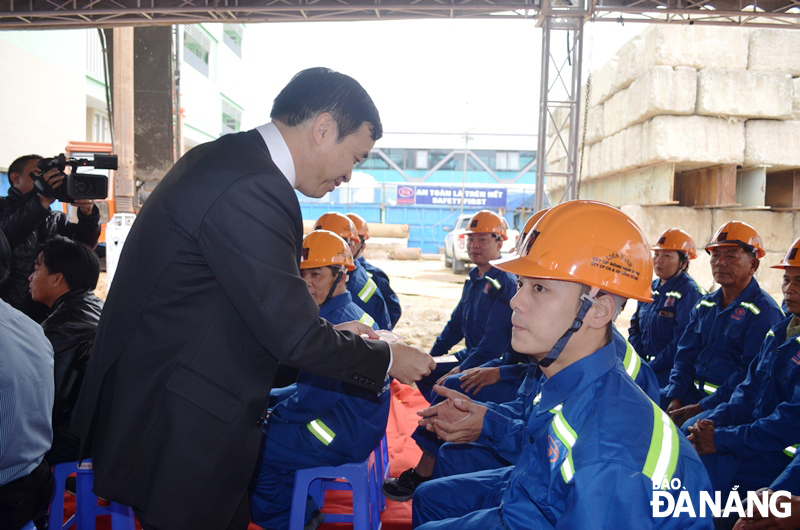 Phó Chủ tịch UBND thành phố Lê Trung Chinh tặng quà, cho các công nhân trong buổi ra quân đầu năm mới. ảnh THU HÀ