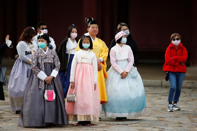 Khách du lịch đeo khẩu trang để ngăn virus corona lây lan tại Seoul, Hàn Quốc. Hàn Quốc đã thuê 2 máy bay chở 700 công dân nước này khỏi Vũ Hán, tuy nhiên các chuyến bay cuối cùng bị hoãn không lý do. (Ảnh: Reuters)
