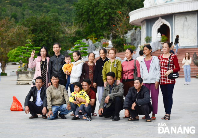Members of a 3-generation family taking a souvenir photo at the Linh Ung Pagoda