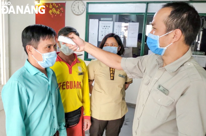 Employees at the Furama Resort Danang have their body temperature checked 