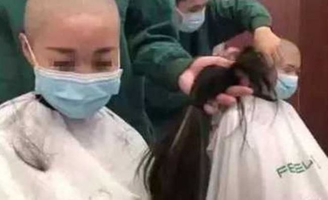 Video các nữ y tá cạo trọc đầu để thuận tiện trong việc chữa trị cho bệnh nhân. Ảnh: BBC