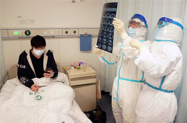 Nhân viên y tế điều trị cho bệnh nhân nhiễm COVID-19 tại bệnh viện ở Vũ Hán, tỉnh Hồ Bắc, Trung Quốc, ngày 18-2-2020. (Ảnh: THX/TTXVN)