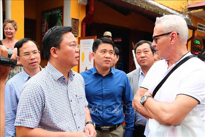 Chủ tịch UBND tỉnh Quảng Nam Lê Trí Thanh (bên trái) trò chuyện cùng du khách quốc tế tham quan Hội An.