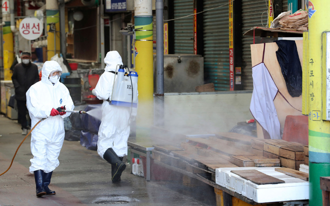 Phun thuốc khử trùng tại một chợ ở Busan, Hàn Quốc.   Ảnh: Yonhap/AP