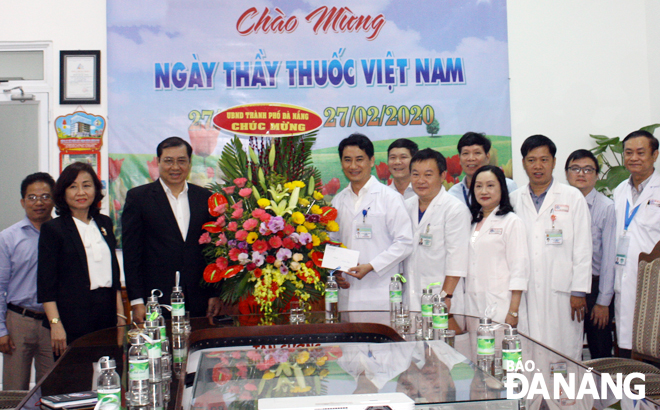 Chủ tịch UBND thành phố Huỳnh Đức Thơ (thứ 3, từ trái sang) chúc mừng cán bộ, nhân viên Bệnh viện Đà Nẵng nhân dịp 27-2. Ảnh: P.C