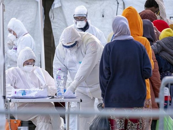 Nhân viên Hội Chữ thập đỏ Italy trong trang phục bảo hộ chống virus SARS-CoV-2 khi tiếp nhận người di cư được giải cứu trên Địa Trung Hải tại khu cảng ở Messina, Sicily ngày 27-2-2020. (Nguồn: AFP/TTXVN)