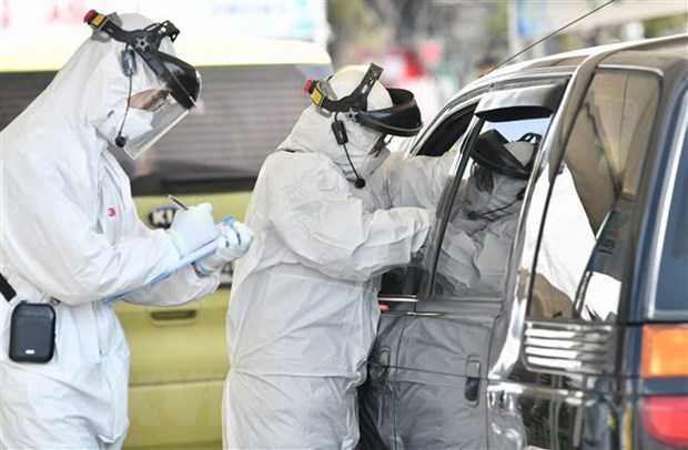 Nhân viên y tế kiểm tra thân nhiệt lái xe nhằm ngăn ngừa sự lây lan của virus SARS-CoV-2 tại Goyang, phía Bắc Seoul ngày 29-2-2020. (Ảnh: AFP/TTXVN)