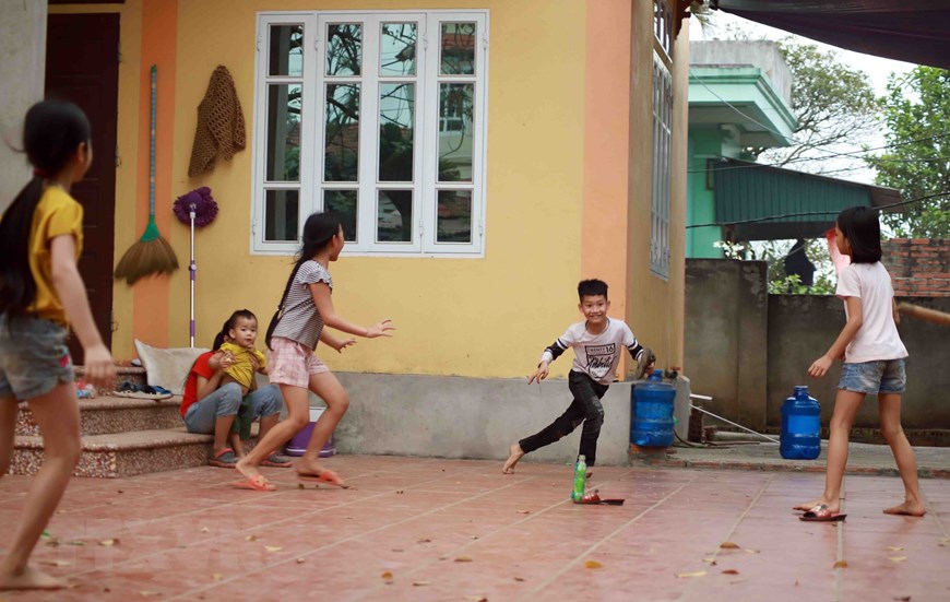 Trẻ em chơi đùa tại sân nhà anh Dũng thôn Ái Văn. (Ảnh: Hoàng Hùng/TTXVN)