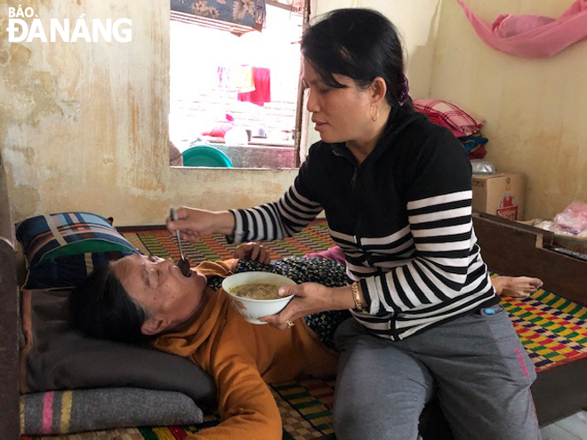 Chị Phan Thị Minh Nguyệt, Chi hội trưởng Chi hội Phụ nữ thôn Nhơn Thọ 2, đến nhà chăm sóc, giúp đỡ bà Võ Thị Trưng bị tai biến. 		                  Ảnh: PHƯƠNG TẤN 