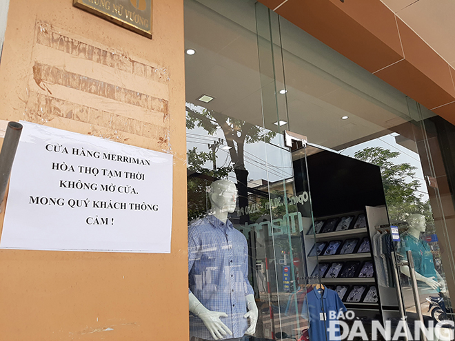 Nhân viên phụ trách cửa hàng thời trang Meriman (thuộc Tổng Công ty Dệt may Hòa Thọ) đóng trên đường Trưng Nữ Vương thông báo cửa hàng bắt đầu đóng cửa từ chiều 10 cho đến hết ngày 14-3. Ảnh: KHÁNH HÒA