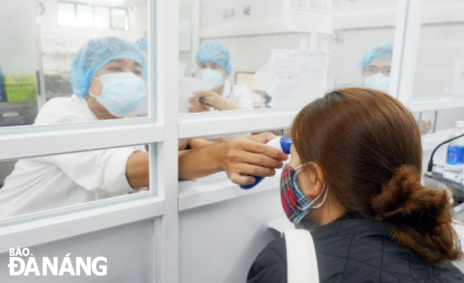 Nhân viên y tế Bệnh viện Đà Nẵng khám cho các trường hợp có triệu chứng ho, sốt, khó thở. Khu vực này được thiết lập tách biệt hoàn toàn với khu vực khám thông thường.       	            Ảnh: PHAN CHUNG 