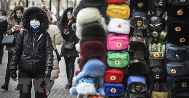 Người dân đeo khẩu trang phòng lây nhiễm dịch COVID-19 trên một đường phố ở Moskva, Nga. (Nguồn: AFP/TTXVN)