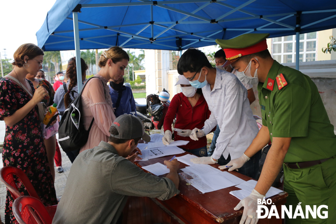 Hành khách từ Quảng Nam ra Đà Nẵng được đo thân nhiệt và khai báo y tế tại điểm kiểm soát Covid-19 trên đường Trần Đại Nghĩa (phường Hòa Hải, quận Ngũ Hành Sơn). Ảnh: M.V
