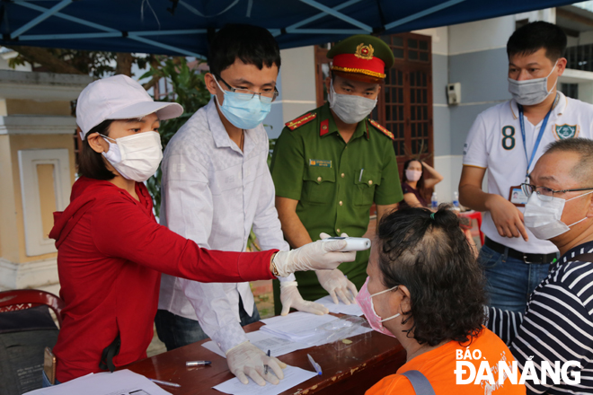 Hành khách từ Quảng Nam ra Đà Nẵng được đo thân nhiệt và khai báo y tế tại điểm kiểm soát Covid-19 trên đường Trần Đại Nghĩa (phường Hòa Hải, quận Ngũ Hành Sơn). Ảnh: M.V  