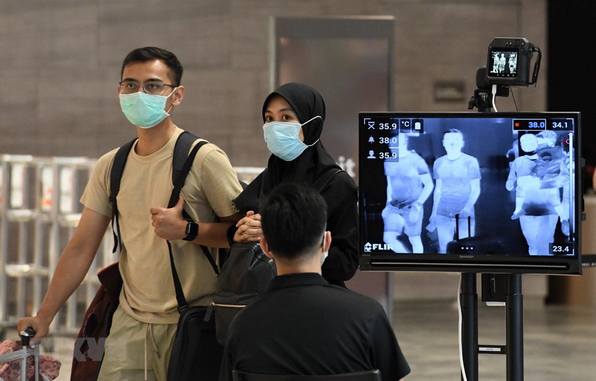 Hành khách đeo khẩu trang để phòng tránh lây nhiễm Covid-19 tại sân bay quốc tế Changi, Singapore. (Ảnh: AFP/TTXVN)