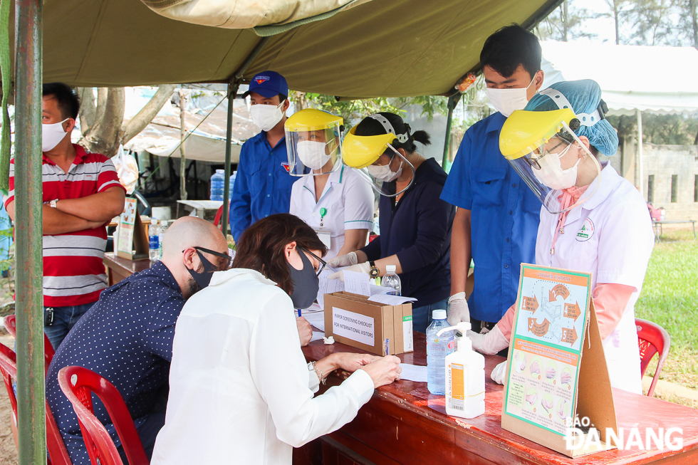 Nhiệm vụ của các bạn trẻ này là hỗ trợ nhân viên y tế kiểm soát thân nhiệt, phiên dịch và hướng dẫn du khách nước ngoài làm tờ khai y tế. Ảnh: XUÂN SƠN 