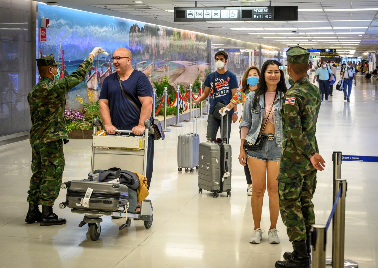 Trong ảnh: Binh sĩ Thái Lan kiểm tra thân nhiệt hành khách tại sân bay quốc tế Phuket nhằm ngăn chặn sự lây lan của dịch Covid-19, ngày 19-3-2020. Ảnh: AFP/TTXVN