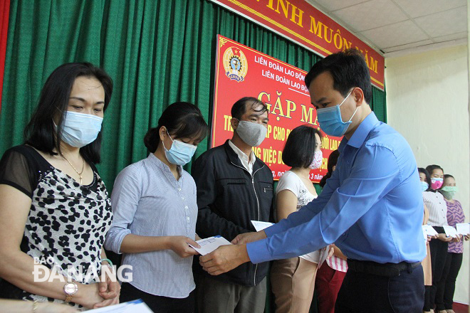 Chủ tịch Liên đoàn Lao động thành phố Nguyễn Duy Minh (bìa phải) trao quà hỗ trợ cho đoàn viên quận Hải Châu mất việc do Covid-19. Ảnh: L.P