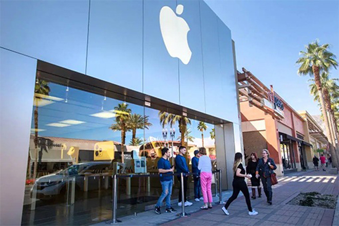 Các nhân viên của Apple Store đứng bên ngoài cửa hàng Palm Desert, California đang đóng cửa để trả lời các câu hỏi của khách hàng vào ngày 14-3. 