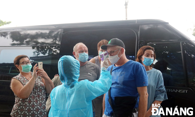 Sinh viên y khoa hỗ trợ ngành y tế kiểm tra thân nhiệt du khách tại các điểm chốt chặn trên địa bàn thành phố Ảnh: PHAN CHUNG