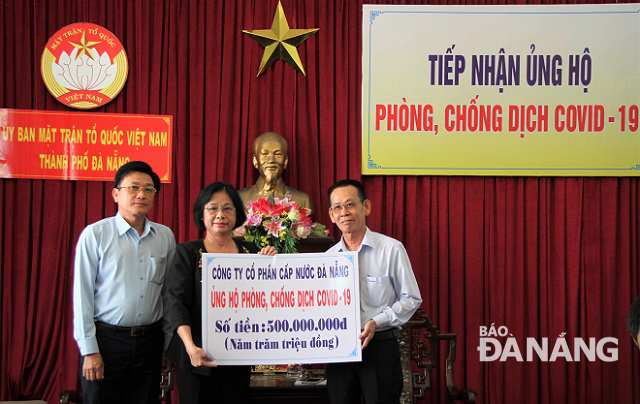 Chủ tịch Ủy ban MTTQ Việt Nam thành phố Đặng Thị Kim Liên () tiếp nhận kinh phí ủng hộ từ Công ty Cổ phần cấp nước Đà Nẵng. Ảnh: LAM PHƯƠNG
