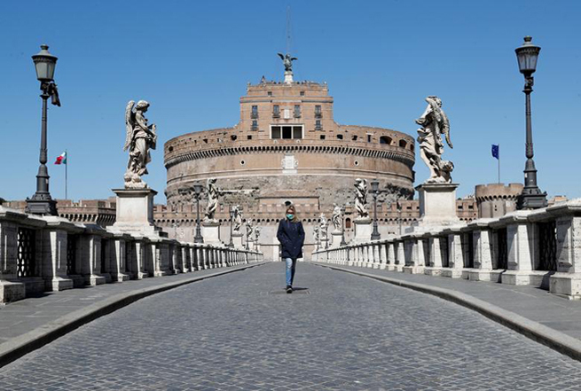 Người phụ nữ đeo khẩu trang trên cây cầu vắng người tại Rome (Italy).