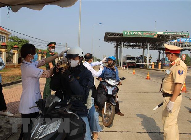 Lực lượng chức năng đo thân nhiệt các lái xe môtô đi vào địa bàn tỉnh Đắk Nông. (Ảnh: Ngọc Minh/TTXVN)