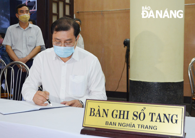 Chủ tịch UBND thành phố Huỳnh Đức Thơ ghi vào sổ tang Thiếu tá Đặng Thanh Tuấn. Ảnh: NGỌC PHÚ