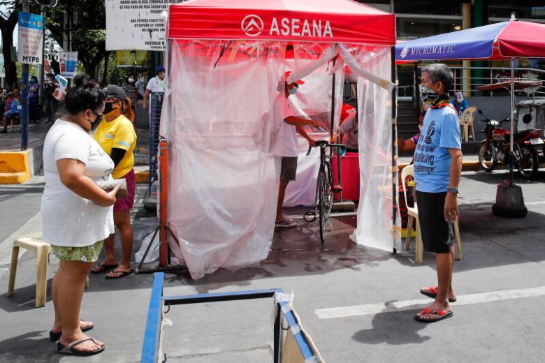 Người dân được kiểm tra thân nhiệt trước khi khử khuẩn tại Manila, Philippines, ngày 6/4. Ảnh: EPA-EFE
