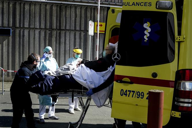 Chuyển bệnh nhân mắc COVID-19 từ xe cứu thương vào một bệnh viện ở Brussels, Bỉ ngày 25/3/2020. Ảnh: AFP/TTXVN 