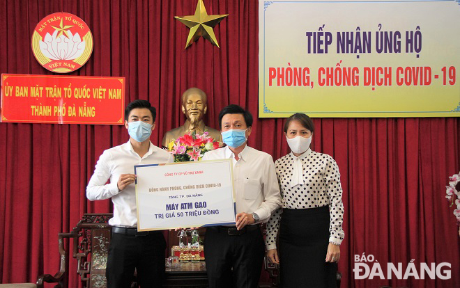 Phó Chủ tịch Thường trực Ủy ban MTTQ Việt Nam thành phố Trần Việt Dũng tiếp nhận ủng hộ máy ATM phát gạo từ Công ty CP Vũ trụ xanh. Ảnh: LAM PHƯƠNG