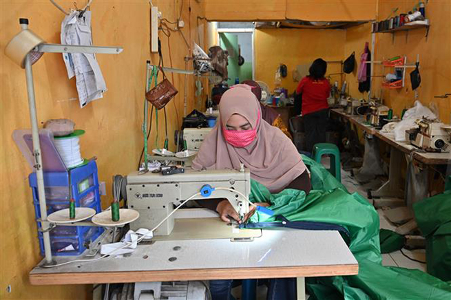 Công nhân may đồ bảo hộ y tế cá nhân và khẩu trang phòng lây nhiễm Covid-19 tại Tangerang, Indonesia, ngày 7-4-2020. Ảnh: AFP/TTXVN