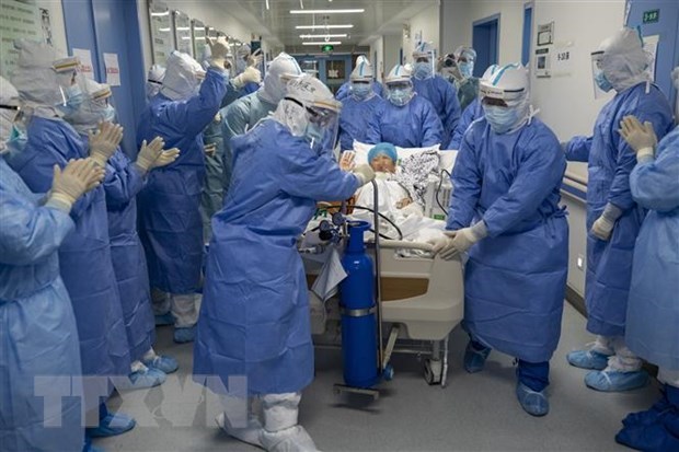 Nhân viên y tế chuyển bệnh nhân mắc COVID-19 tới phòng điều trị tích cực tại một bệnh viện ở Vũ Hán, Trung Quốc ngày 12-4. (Ảnh: THX/TTXVN)