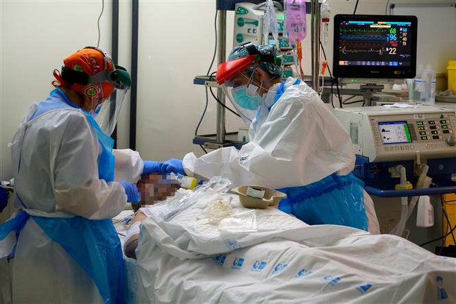  Nhân viên y tế điều trị cho bệnh nhân nhiễm COVID-19 tại bệnh viện ở Alcala de Henares, gần Madrid, Tây Ban Nha ngày 22/4/2020. Ảnh: AFP/TTXVN