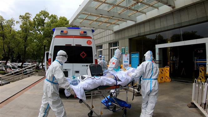  Nhân viên y tế chuyển bệnh nhân mắc COVID-19 tới bệnh viện ở Vũ Hán, Trung Quốc ngày 14/4/2020. Ảnh: THX/TTXVN
