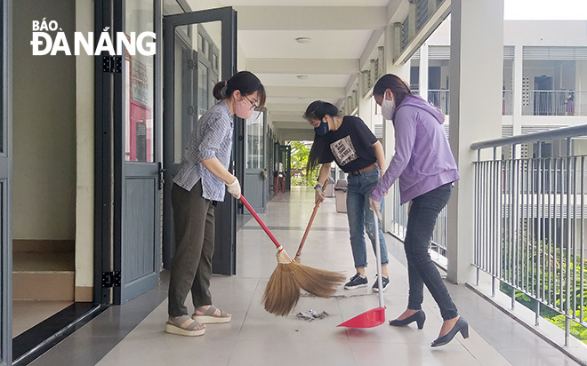Giáo viên tổ Vật Lý Trường THPT Phan Châu Trinh dọn dẹp vệ sinh trường lớp. Ảnh: N.P