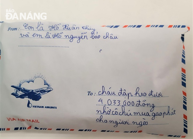 Chiếc phong bì đựng số tiền hỗ trợ của hai bé Hồ Xuân Thùy và Hồ Nguyễn Bảo Châu. Ảnh: LAM PHƯƠNG