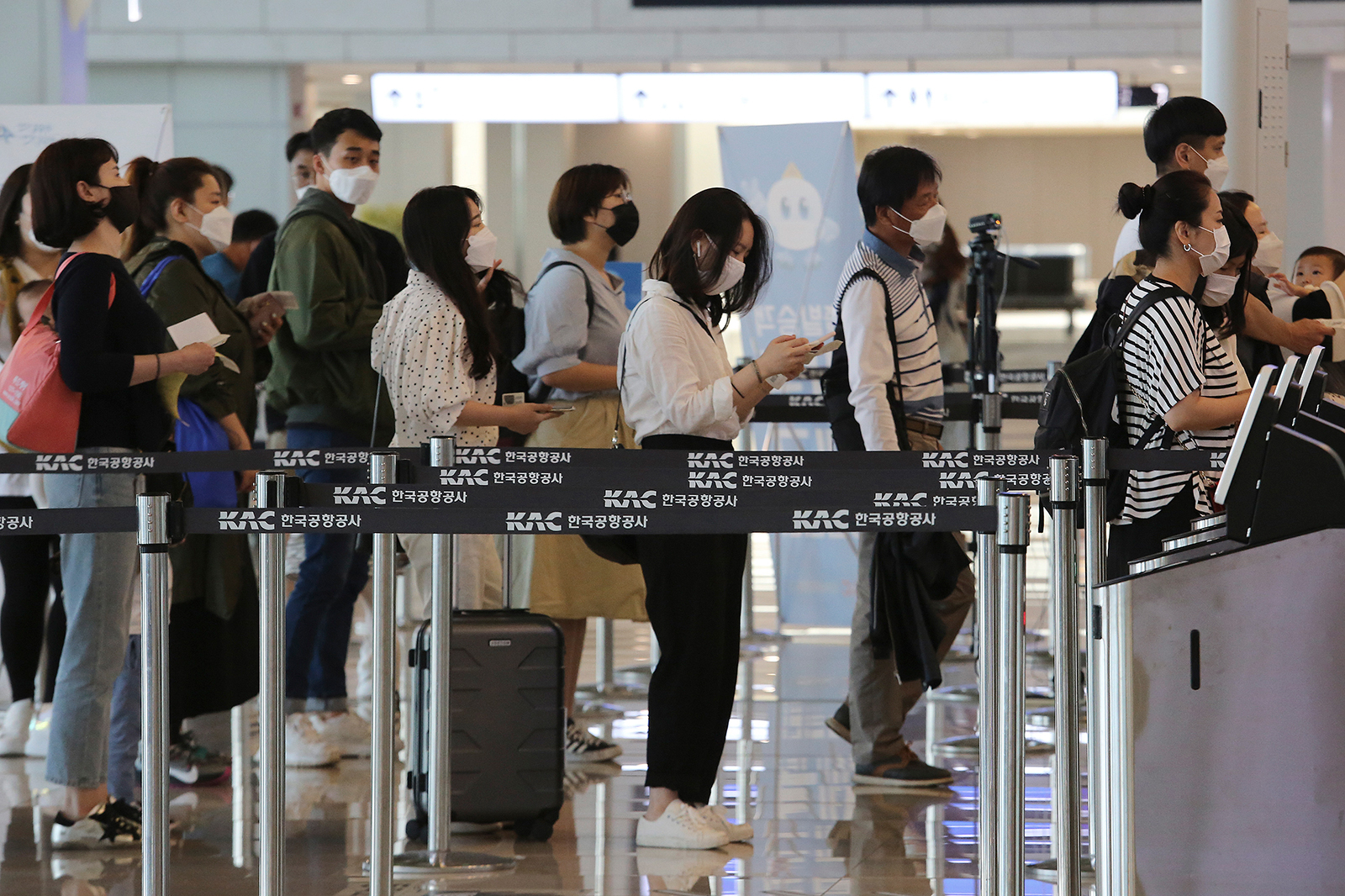 Hành khách mang khẩu trang lên máy bay tại ga quốc nội ở sân bay Gimpo, thủ đô Seoul ngày 27-5. Ảnh: AP