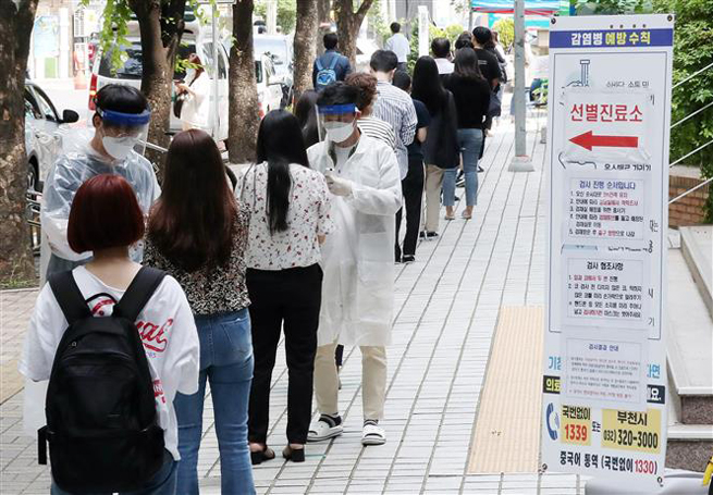 Người dân xếp hàng chờ xét nghiệm Covid-19 tại Bucheon, phía tây thủ đô Seoul, Hàn Quốc ngày 28-5-2020. Ảnh: Yonhap/ TTXVN