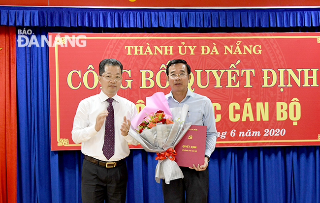 Phó Bí thư Thường trực Thành ủy Nguyễn Văn Quảng (bìa trái) trao quyết định cho ông Đàm Quang Hưng. Ảnh: ĐẶNG NỞ