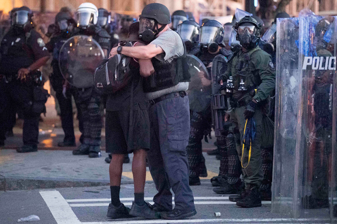 Một nhân viên cảnh sát ôm người biểu tình ở thành phố Atlanta, bang Georgia. Ảnh: AP	