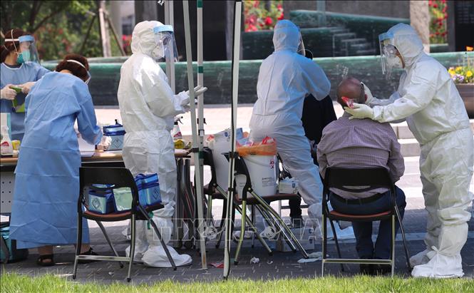 Nhân viên y tế lấy mẫu xét nghiệm COVID-19 cho người dân tại Seoul, Hàn Quốc ngày 29/5. Ảnh: AFP/TTXVN